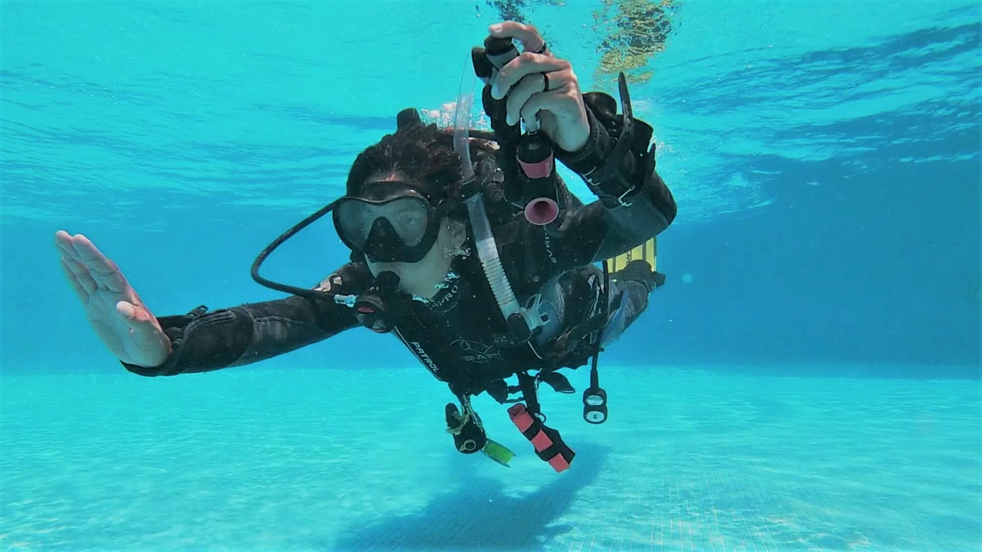 female PADI instructor underwater in pool