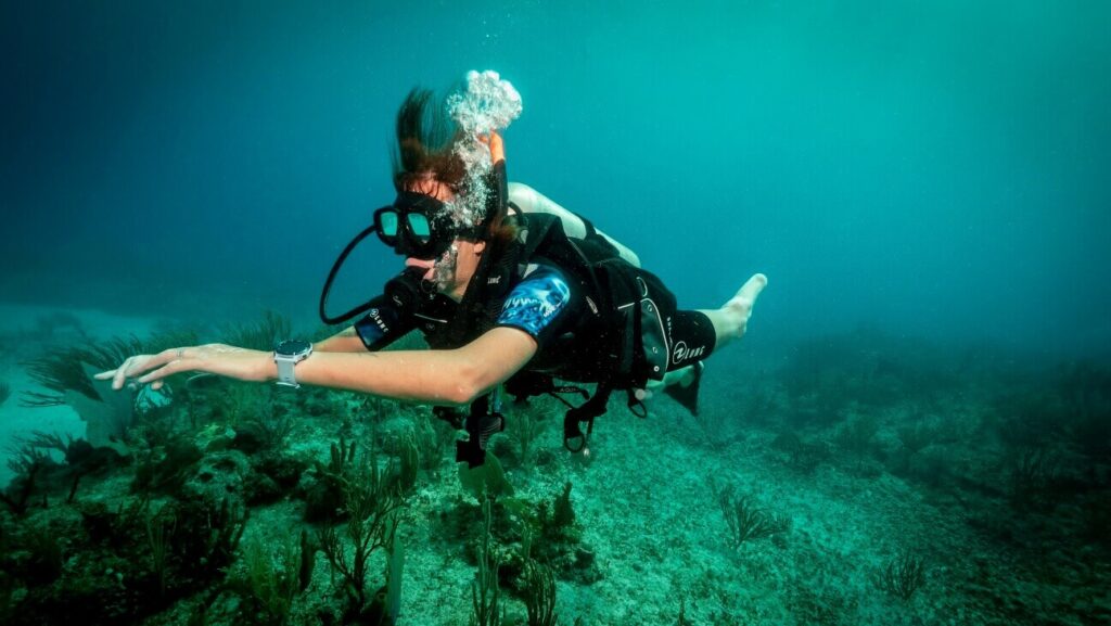 amputee scuba diving on coral reef