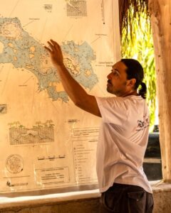 diving instructor giving briefing at a cenote in front of map