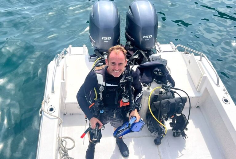 Scuba Instructor standing on boat before a dive